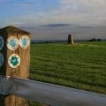 Waymarks on a fence post and a trig point